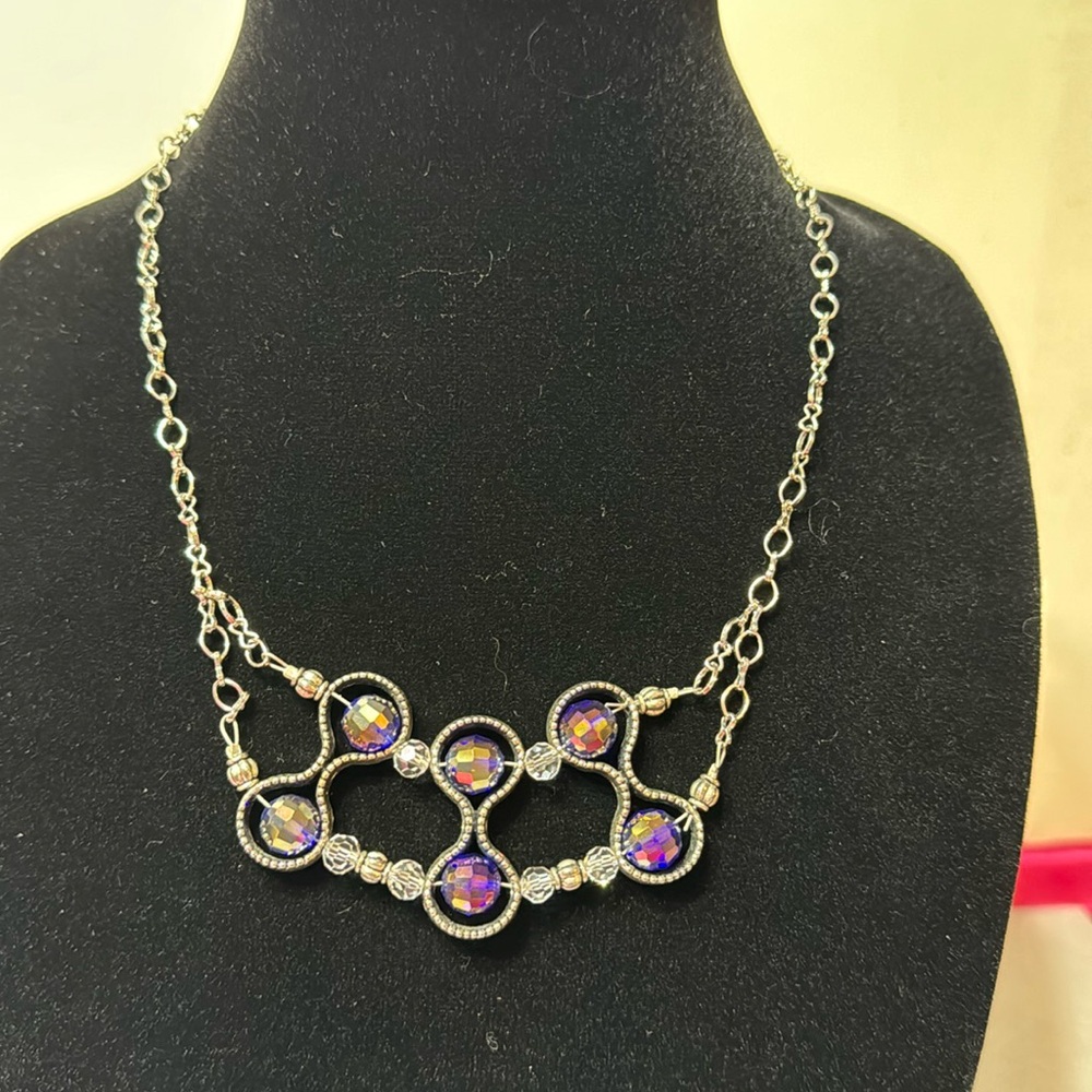 Silver colored chain with 6 purple reflective beads.